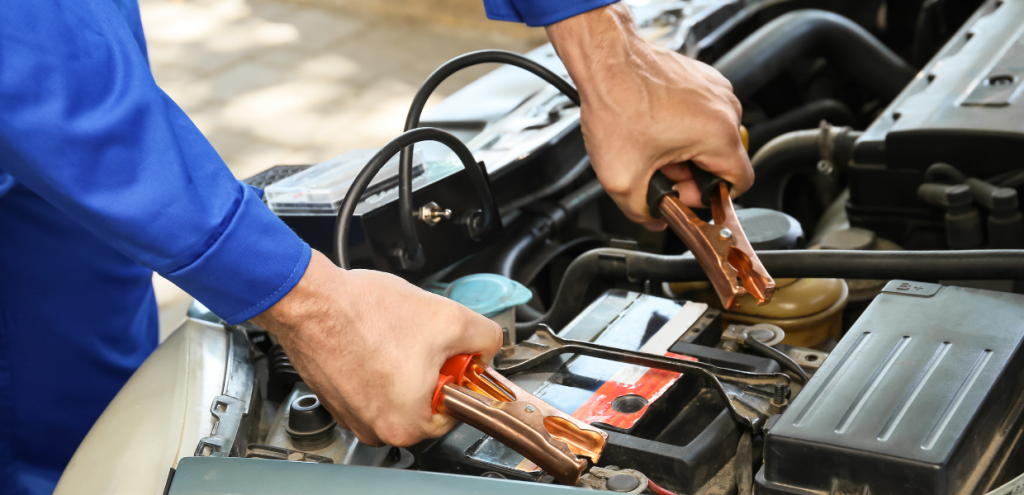 uomo che carica una batteria auto